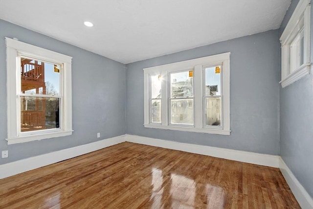 unfurnished room with hardwood / wood-style flooring and a wealth of natural light