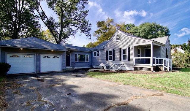 view of front of house featuring a front lawn, covered porch, and a garage