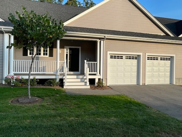 view of front of home with a front lawn, a porch, and a garage