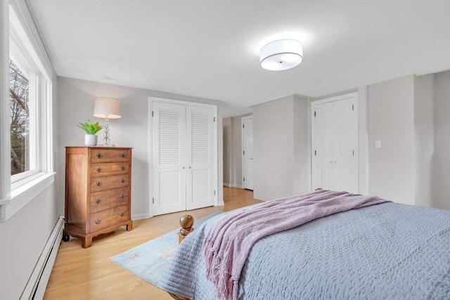 bedroom featuring light wood-style floors and a baseboard radiator