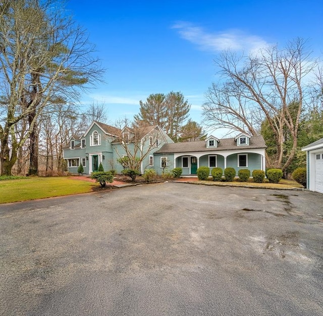 view of front of house featuring a front lawn, a garage, and aphalt driveway