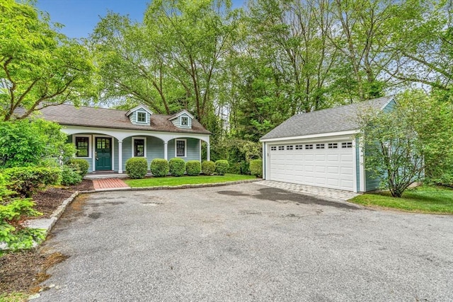 1731 Lowell Rd, Concord, MA 01742 - view of front of property featuring a porch, a garage, a shingled roof, and an outdoor structure