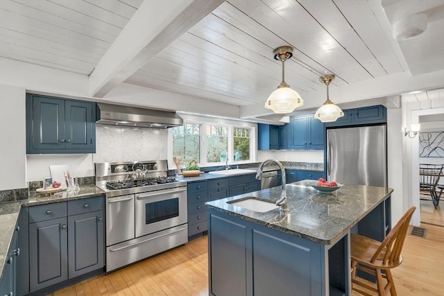 kitchen with a sink, stainless steel appliances, blue cabinets, and range hood