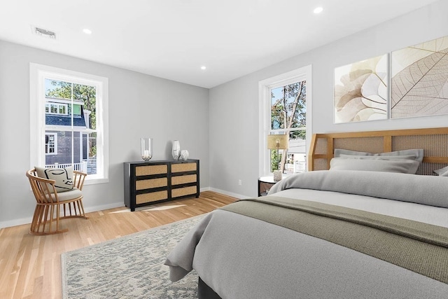 bedroom with light wood-type flooring and multiple windows