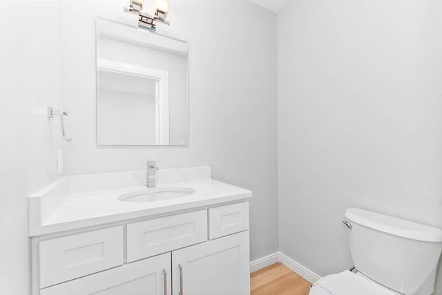 bathroom with vanity, toilet, and wood-type flooring