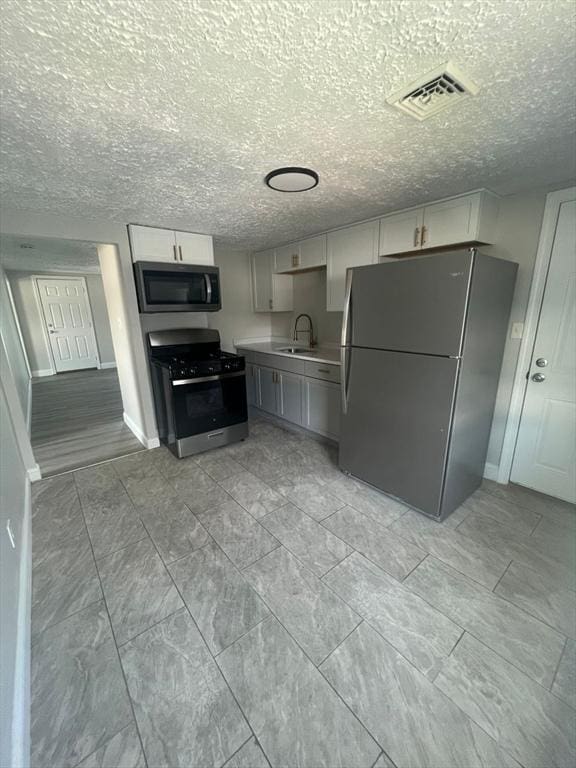 kitchen with stainless steel appliances, gray cabinets, and sink