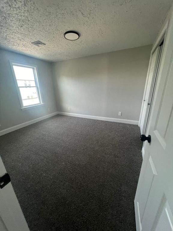 spare room with carpet and a textured ceiling