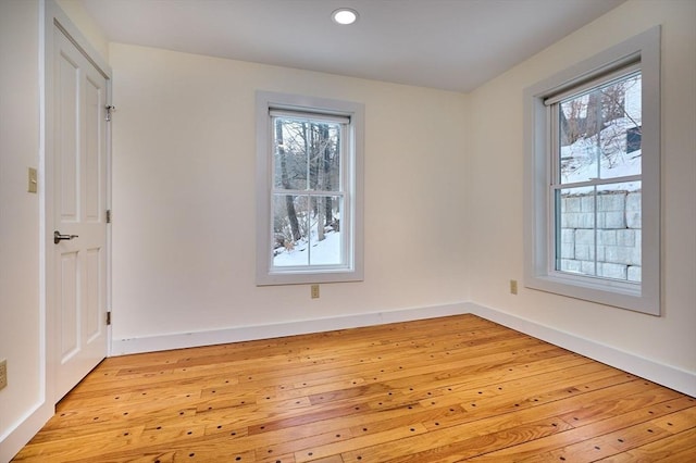 unfurnished room featuring recessed lighting, plenty of natural light, baseboards, and light wood-type flooring