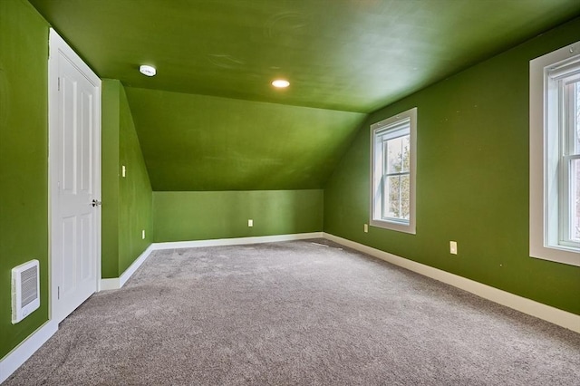 bonus room featuring baseboards, carpet floors, lofted ceiling, and visible vents