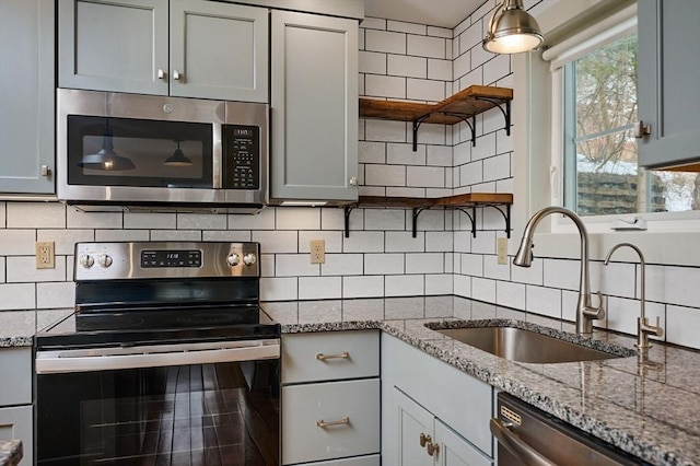 kitchen with tasteful backsplash, a sink, appliances with stainless steel finishes, and open shelves