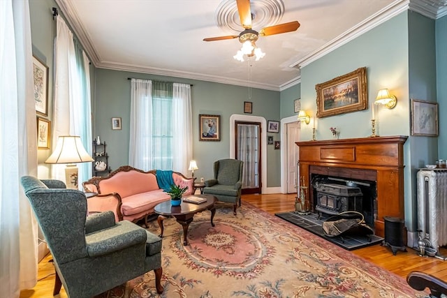52 Central, Gardner, MA 01440 - living area featuring wood finished floors, a wood stove, ceiling fan, crown molding, and baseboards