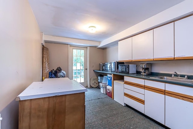 52 Central, Gardner, MA 01440 - kitchen featuring a sink, white cabinets, dark colored carpet, and black microwave