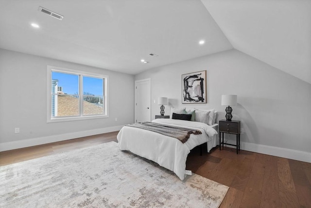 bedroom with lofted ceiling and dark hardwood / wood-style floors