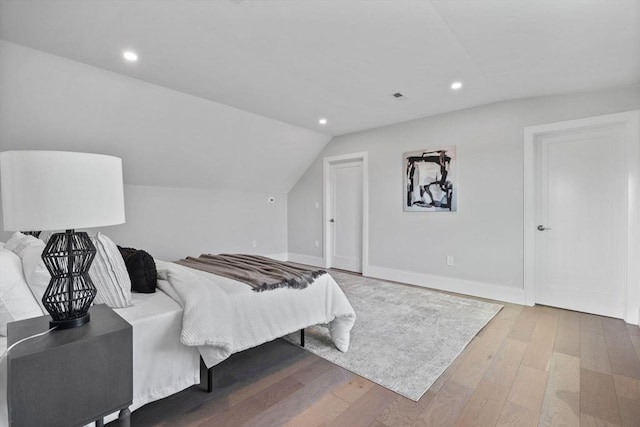 bedroom with lofted ceiling and wood-type flooring