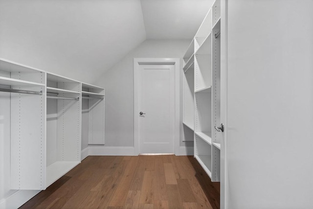 walk in closet featuring dark wood-type flooring and vaulted ceiling