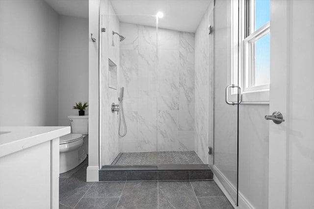 bathroom with toilet, a shower with shower door, and vanity