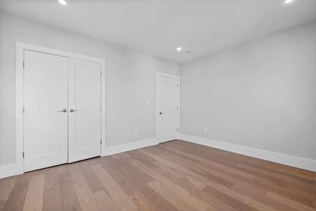 unfurnished bedroom with light wood-type flooring and a closet