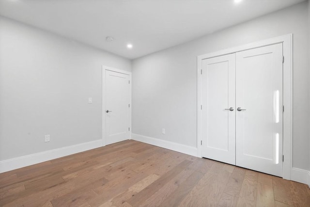 unfurnished bedroom featuring light hardwood / wood-style floors and a closet