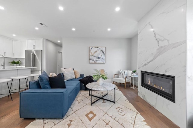 living room featuring light wood-type flooring and a fireplace