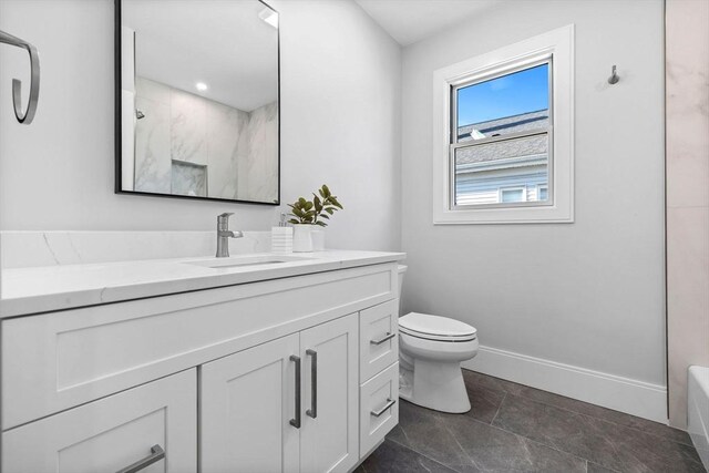 bathroom featuring toilet, vanity, and tile patterned flooring