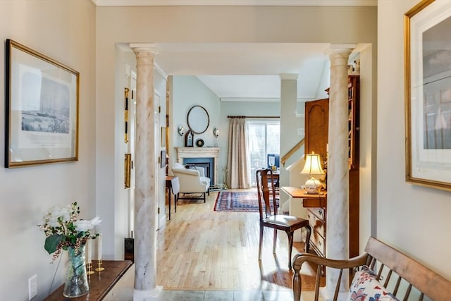 hallway with light wood-style flooring and ornate columns