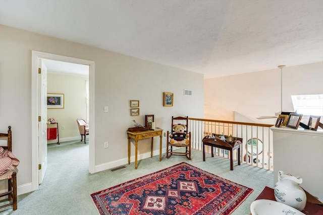 sitting room with visible vents, light carpet, and baseboards