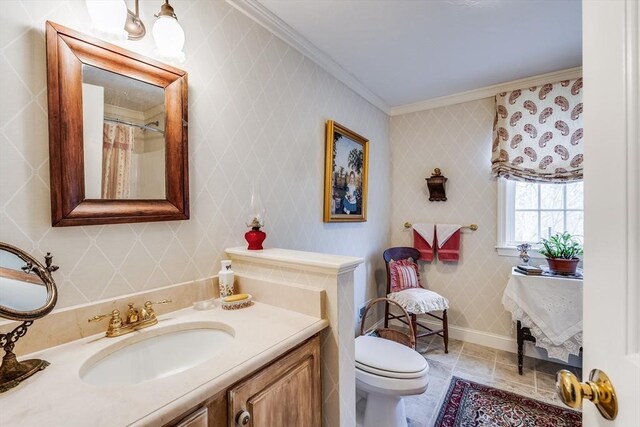 bathroom featuring toilet, crown molding, vanity, baseboards, and wallpapered walls