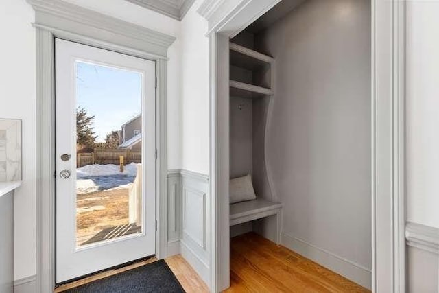 mudroom with light wood finished floors and wainscoting