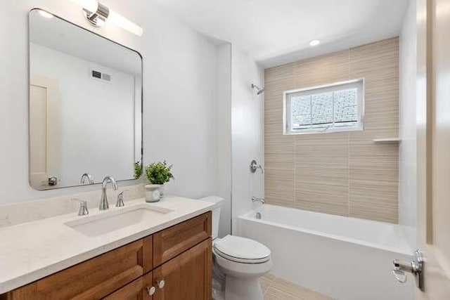 bathroom with visible vents, vanity, toilet, and tub / shower combination