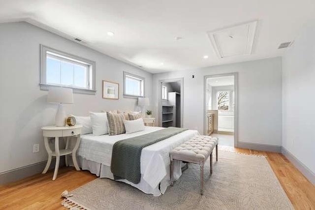 bedroom with light wood finished floors, attic access, visible vents, baseboards, and recessed lighting