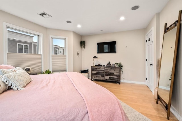 bedroom featuring a barn door and light wood-type flooring