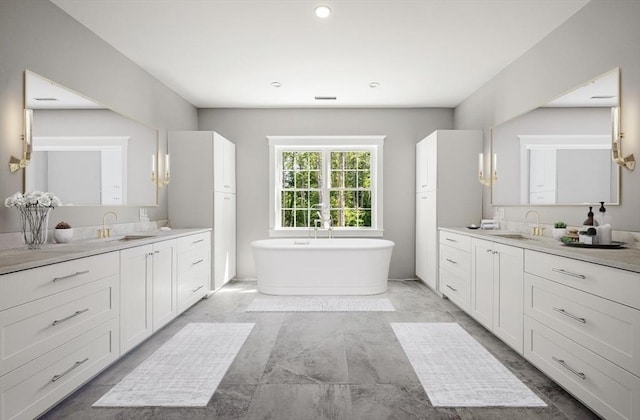 bathroom with vanity and a washtub