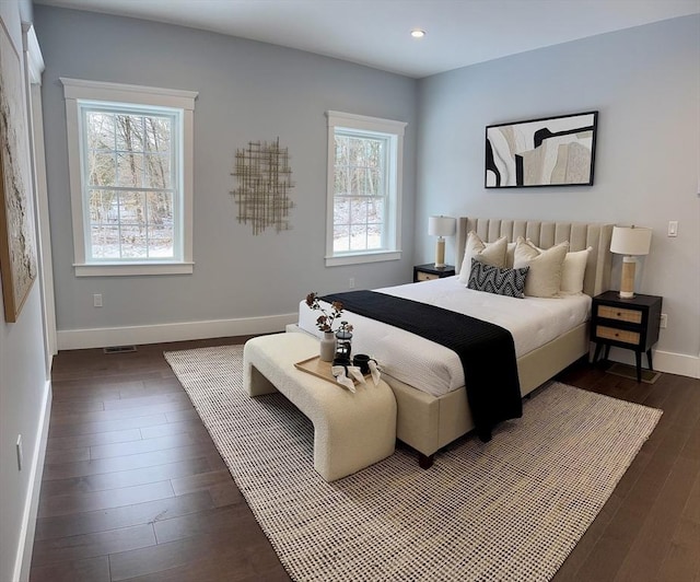 bedroom featuring dark hardwood / wood-style flooring and multiple windows