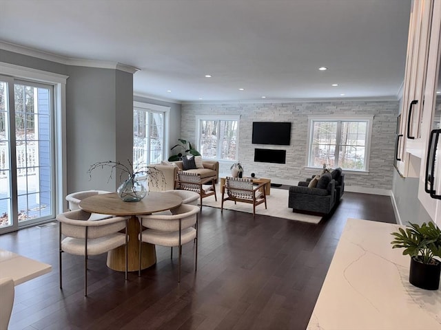 living room with ornamental molding, a stone fireplace, and dark hardwood / wood-style floors