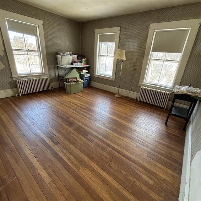 misc room with a healthy amount of sunlight, radiator, and dark hardwood / wood-style flooring