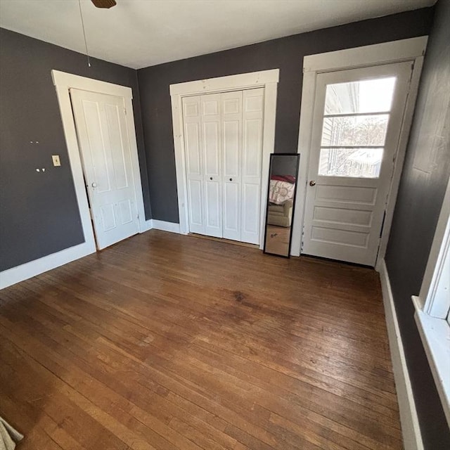 unfurnished bedroom featuring dark wood-type flooring and ceiling fan