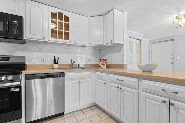 100 Park Terrace Dr Unit 124, Stoneham, MA 02180 - kitchen with stainless steel appliances, a sink, glass insert cabinets, decorative backsplash, and white cabinetry
