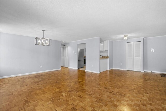 100 Park Terrace Dr Unit 124, Stoneham, MA 02180 - unfurnished living room featuring a chandelier and baseboards