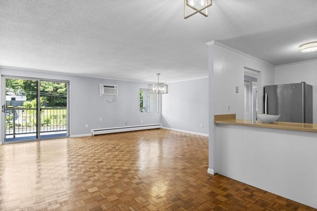 100 Park Terrace Dr Unit 124, Stoneham, MA 02180 - unfurnished living room featuring a baseboard heating unit, a textured ceiling, a chandelier, healthy amount of natural light, and a wall mounted AC