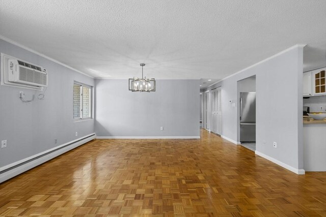 100 Park Terrace Dr Unit 124, Stoneham, MA 02180 - spare room featuring a wall mounted AC, baseboard heating, a textured ceiling, a chandelier, and crown molding