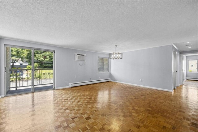 100 Park Terrace Dr Unit 124, Stoneham, MA 02180 - unfurnished room with baseboard heating, a chandelier, a textured ceiling, a wall unit AC, and baseboards