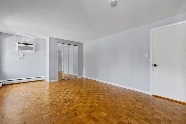 100 Park Terrace Dr Unit 124, Stoneham, MA 02180 - unfurnished room with a wall mounted AC, baseboards, a baseboard radiator, a textured ceiling, and a smoke detector
