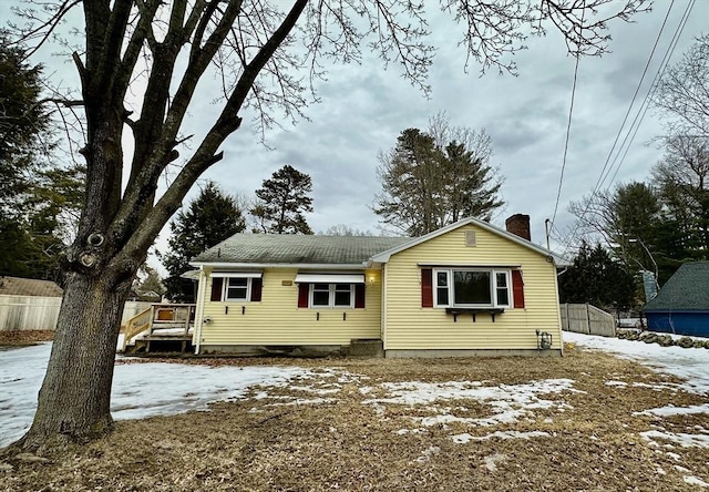 view of front facade with fence and a chimney