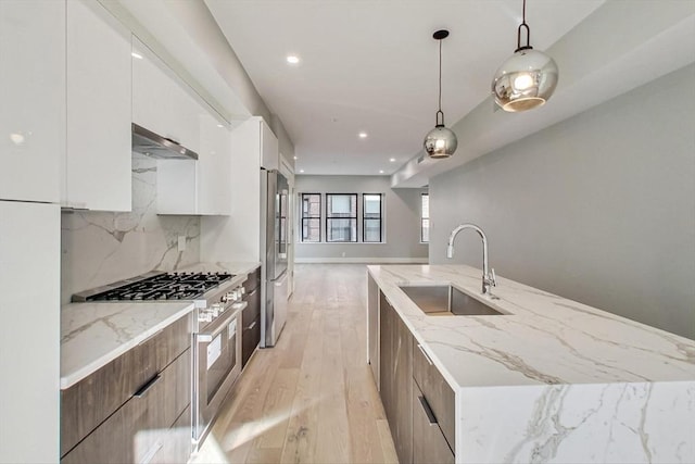 kitchen featuring hanging light fixtures, backsplash, white cabinetry, appliances with stainless steel finishes, and sink