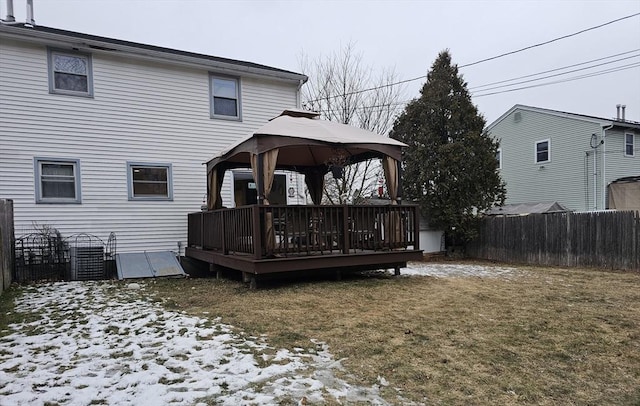 snow covered house with a yard, a gazebo, and a wooden deck