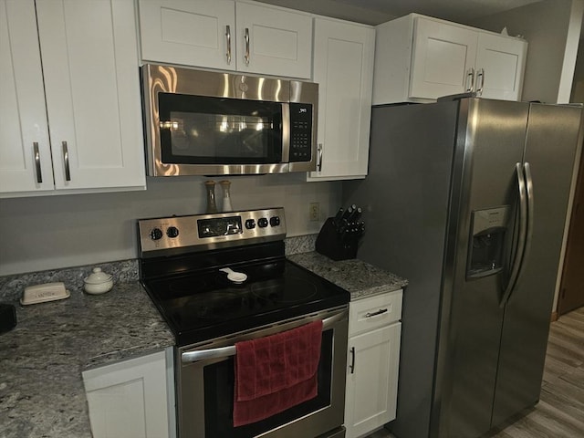 kitchen featuring light stone counters, appliances with stainless steel finishes, and white cabinets