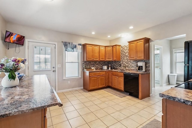 63 Beverly St, Chicopee, MA 01013 - kitchen featuring black dishwasher, light tile patterned flooring, brown cabinets, backsplash, and dark countertops
