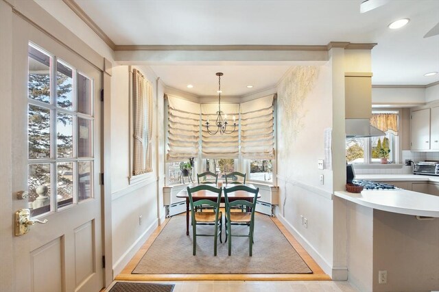 dining space featuring ornamental molding, a healthy amount of sunlight, a baseboard radiator, and a toaster