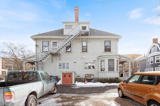 view of front of property with a shingled roof and a chimney