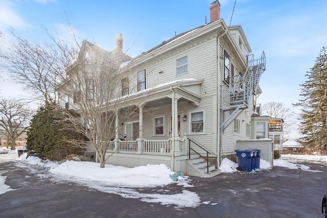 view of front of home featuring a chimney and a porch